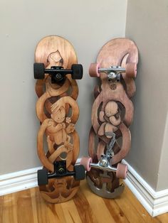 two wooden skateboards sitting on top of a hard wood floor next to each other