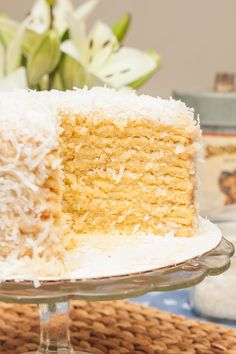 a close up of a slice of cake on a plate with flowers in the background