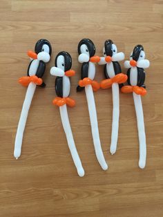 four penguin shaped toothbrushes sitting on top of a wooden table