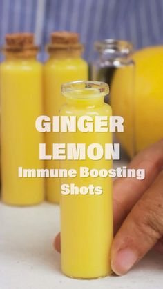 a person pouring orange juice into a glass bottle with the words ginger lemon in front of them