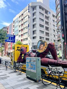 an inflatable man laying on the side of a road next to parked bicycles