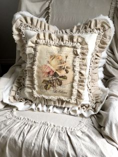 a white pillow with ruffled edges on top of a bed