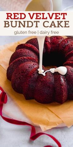 a red velvet bundt cake with white icing is on a yellow plate and has a red ribbon around it