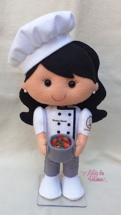 the doll is wearing a chef's outfit and holding a bowl of fruit in her hands