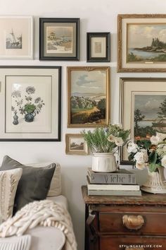 a living room filled with lots of pictures on the wall next to a couch and coffee table