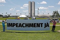 two people holding up a large banner in front of a building that says impeachment ja