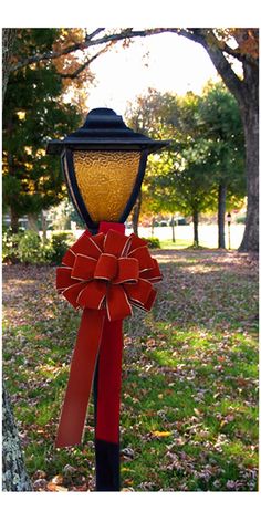 a street light with a red bow on it's ribbon around the top and bottom