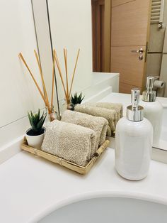 a bathroom counter with towels and soap dispenser on it, next to a mirror