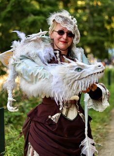 a woman dressed in costume holding a white dragon