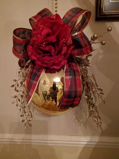 a red rose hanging from the side of a wall with a bow on it's head