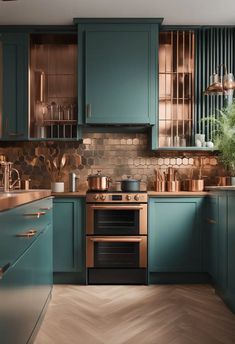 a kitchen with green cabinets and copper accents on the walls, along with wooden flooring