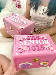 two pink boxes that say siss senior 2013 and the other one has flowers on them