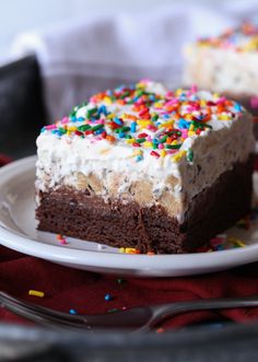 a piece of chocolate cake with sprinkles on it sitting on a plate