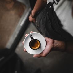 a person holding a coffee cup and saucer