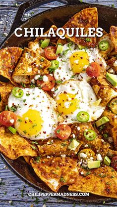 a skillet filled with nachos topped with fried eggs and tomatoes on top