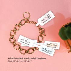 a bracelet with name tags attached to it on a pink surface next to a potted plant