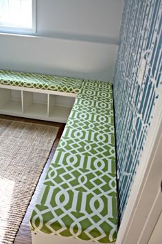 a green and white bench sitting next to a window