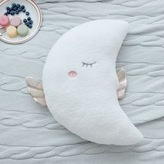 a white pillow with an angel's wing on it next to a plate of candy