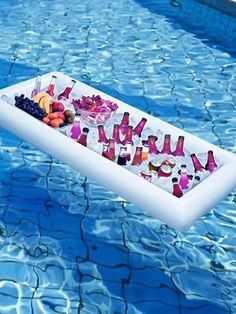 an inflatable pool float filled with drinks and snacks on the edge of a swimming pool