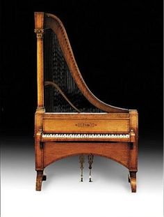 an old piano sitting in front of a black background