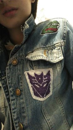 a person wearing a denim jacket with patches on it