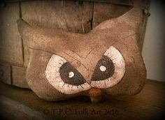 an owl pillow sitting on top of a wooden shelf