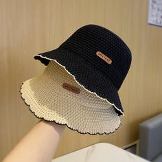 two hats that are on top of each other in front of a wooden wall,