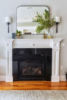 a living room with a fire place and mirror on the fireplace mantel above it