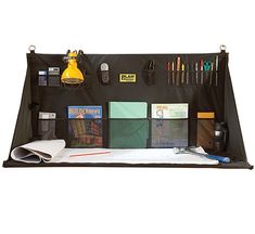 an organized desk with pens, notebooks and other office supplies on it's side