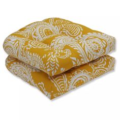 two yellow and white cushions on top of each other, one with an intricate pattern