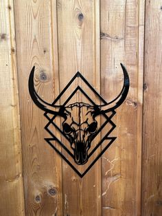 a metal bull skull with horns on a wooden fence