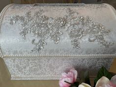 a white purse with silver sequins and flowers