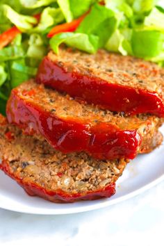 two slices of meatloaf on a plate with salad