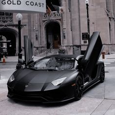 a black sports car parked in front of a building