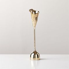 a gold vase sitting on top of a white table