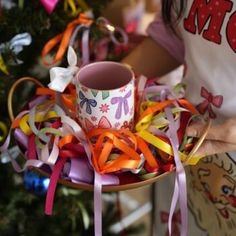 a person holding a cup with ribbons around it