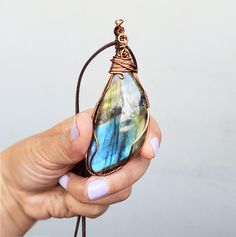 A beautiful colorful Labradorite wire wrapped with a sturdy tarnish free copper wire. This lovely pendant has a simple style wrap and the stone has some pretty tones of blue, green, yellow and purple. I wrap all of my jewelry with a sturdy tarnish free wire. Please view all of the photos for details and choose your chain length at checkout. All jewelry will come in a jewelry box or bag perfect to give as a gift. Need a personalized note? Let me know what you would like it to say. Buy more then o Spiritual Jewelry With Natural Stones And Waxed Cord, Adjustable Necklace With Oval Pendant And Natural Stones, Spiritual Jewelry With Natural Stones On Waxed Cord, Adjustable Oval Pendant Necklace With Natural Stones, Handmade Oval Labradorite Necklace, Artisan Adjustable Necklace With Oval Pendant, Adjustable Oval Necklace With Natural Stones, Nature-inspired Hand Wrapped Labradorite Necklace, Bohemian Oval Hand-wrapped Necklaces