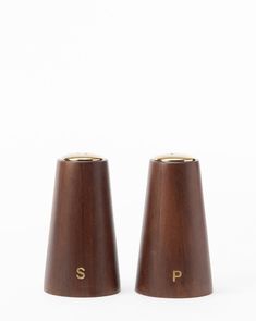 two wooden salt and pepper shakers with the letters p on each side, set against a white background