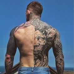 a man with many tattoos on his back