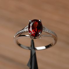 It is a natural garnet ring. The main stone is 7mm*9mm oval cut, weight about 2.33 carats. The basic metal is sterling silver and plated with rhodium. To change the metal to a solid gold (white/rose) or platinum is also available, please ask for a quotation if you want. You can also go to my shop Home for more elegant rings: https://www.etsy.com/shop/godjewelry?ref=hdr_shop_menu More rings: https://www.etsy.com/shop/godjewelry?ref=l2-shop-header-avatar Customization is always welcome and please Elegant Oval Garnet Birthstone Ring, Silver Oval Ring With Lab-created Ruby, Silver Oval Lab-created Ruby Ring, Silver Oval Garnet Birthstone Ring, Oval Garnet Ring In Silver, Oval Silver Garnet Birthstone Ring, Oval Silver Ruby Promise Ring, Oval Garnet Birthstone Ring In Silver, Oval Garnet White Gold Jewelry