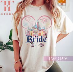 a woman standing in front of a wall wearing a t - shirt that says bride