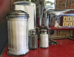 salt and pepper shakers sit on a red counter