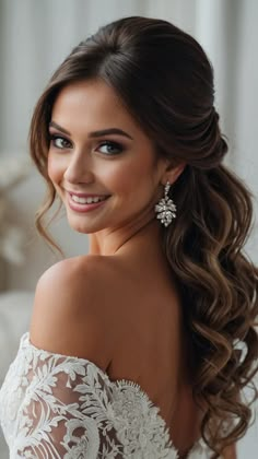 a woman wearing a wedding dress with long hair and earrings on her head, smiling at the camera