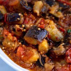 a white bowl filled with stew and vegetables