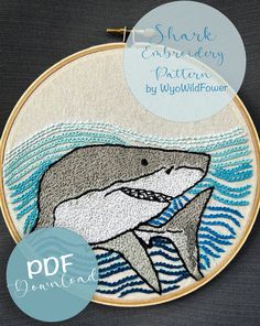 an embroidery project with a dolphin and waves in the water, on top of a black background