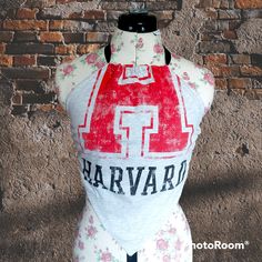 This new bandeau top has been upcycled from a vintage Harvard T-shirt bought locally in Dublin, Ireland. It's perfect for all of the vintage clothes lovers from the 90s and early 2000s! The top is backless with a bandana style front and it's secured at the neck and back with a black ribbon. As the ribbon is fed through channels it can be changed out for a different look or outfit, or the size can be adjusted. It's also reversible!! It'd comfortably fit a size small to medium as it is now. The size of the front can be seen in pictures and the neck ribbon is 32 inches while the back ribbon is 54 inches ** Please note that because the source material is vintage T-Shirts, there may be small flaws, imperfections or fading on the fabric though I've made every effort to avoid them when cutting.** Cotton Racerback Crop Top For Streetwear, Y2k Style Cotton Tank Top For Festivals, Y2k Sleeveless Top For Music Festival, Summer Band Merch Cotton Crop Top, Summer Cotton Crop Top Band Merch, Summer Cotton Crop Top With Band Merch Style, Summer Cotton Crop Top For Band Merch, Retro Fitted Racerback Top, Fitted Retro Racerback Top