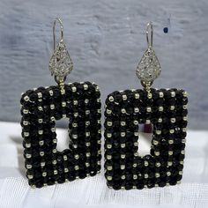 Dramatic black rectangle statement earrings with silver accents.  These beaded earrings are one of a kind, handmade, unique and real  head- turners! Made with high quality Czech facettes and permanent finish silver Japanese seed beads. Permanent finish means they don't tarnish or lose their color. Finished with a silver coloured stainless steel filigree wire earring.  Every item I design is made with the best quality beads, accessories and materials and comes in a handmade embroidered jewellery bag.  Total length: 6,5cm Length drop:  4 cm Width: 3.3 cm Depth:   8 mm Weight (per pair):  22 gr Other colour variations are available in my shop. Unique Black Beaded Dangle Earrings, Unique Handmade Black Earrings, Black Handmade Earrings For Evening, Handmade Black Earrings For Evening, Handmade Beaded Drop Earrings For Evening, Handmade Black Evening Earrings, Handmade Drop Earrings For Evening, Unique Black Earrings For Evening, Black Rectangular Beaded Jewelry