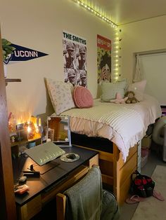 a bed room with a neatly made bed next to a computer desk and other items