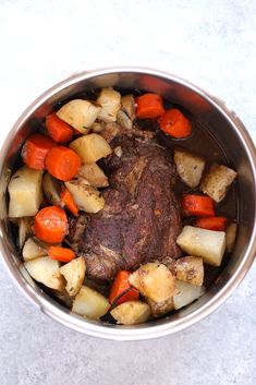 a pot filled with meat, potatoes and carrots