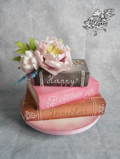 three books stacked on top of each other with flowers in the middle and happy birthday written on them